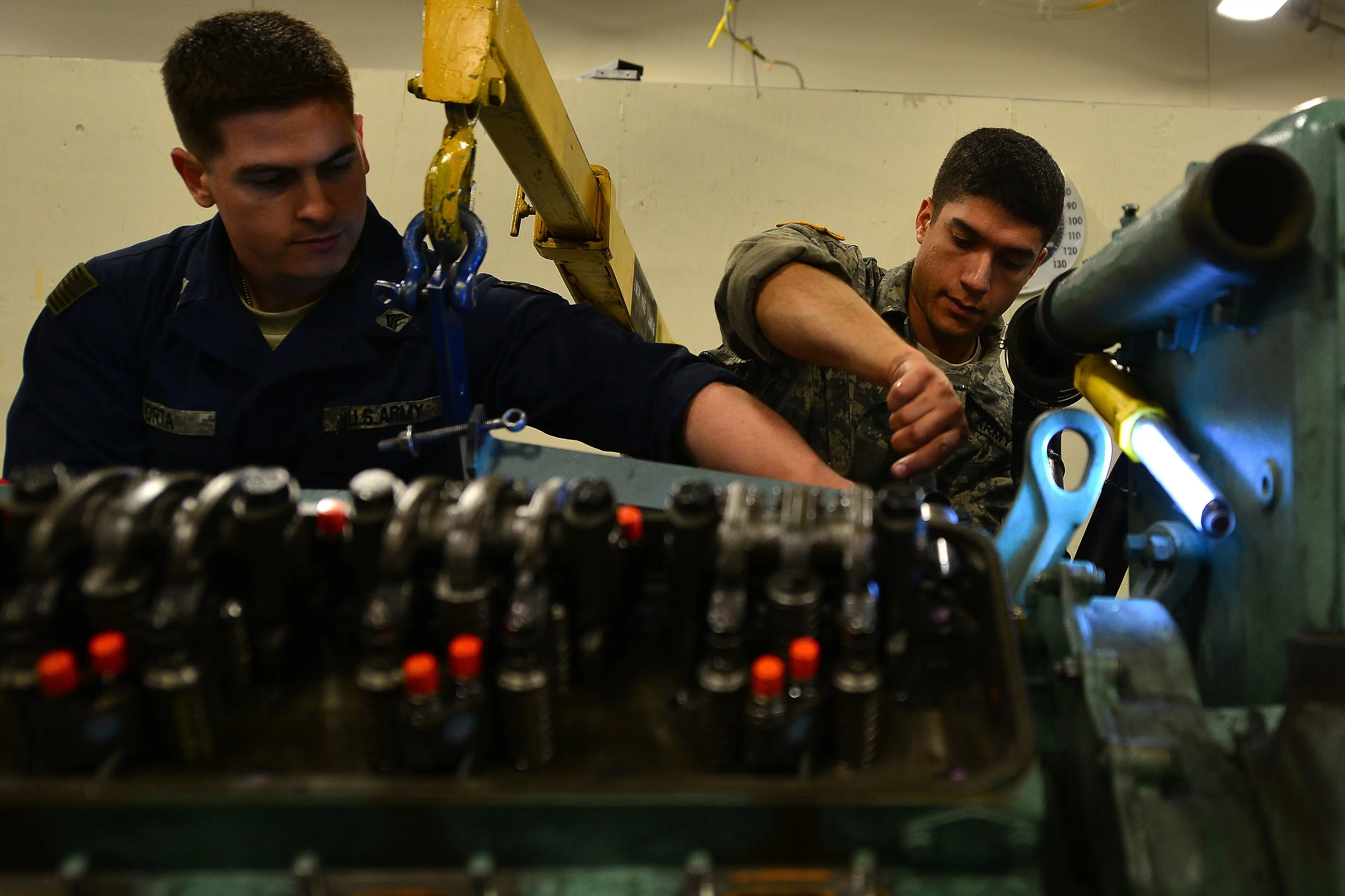 Two mechanics tightening bolts during an engine rebuild